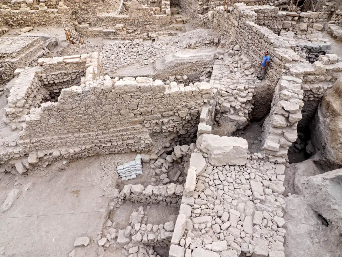 Deep excavation pit with a thick ancient stone wall and sloping rampart