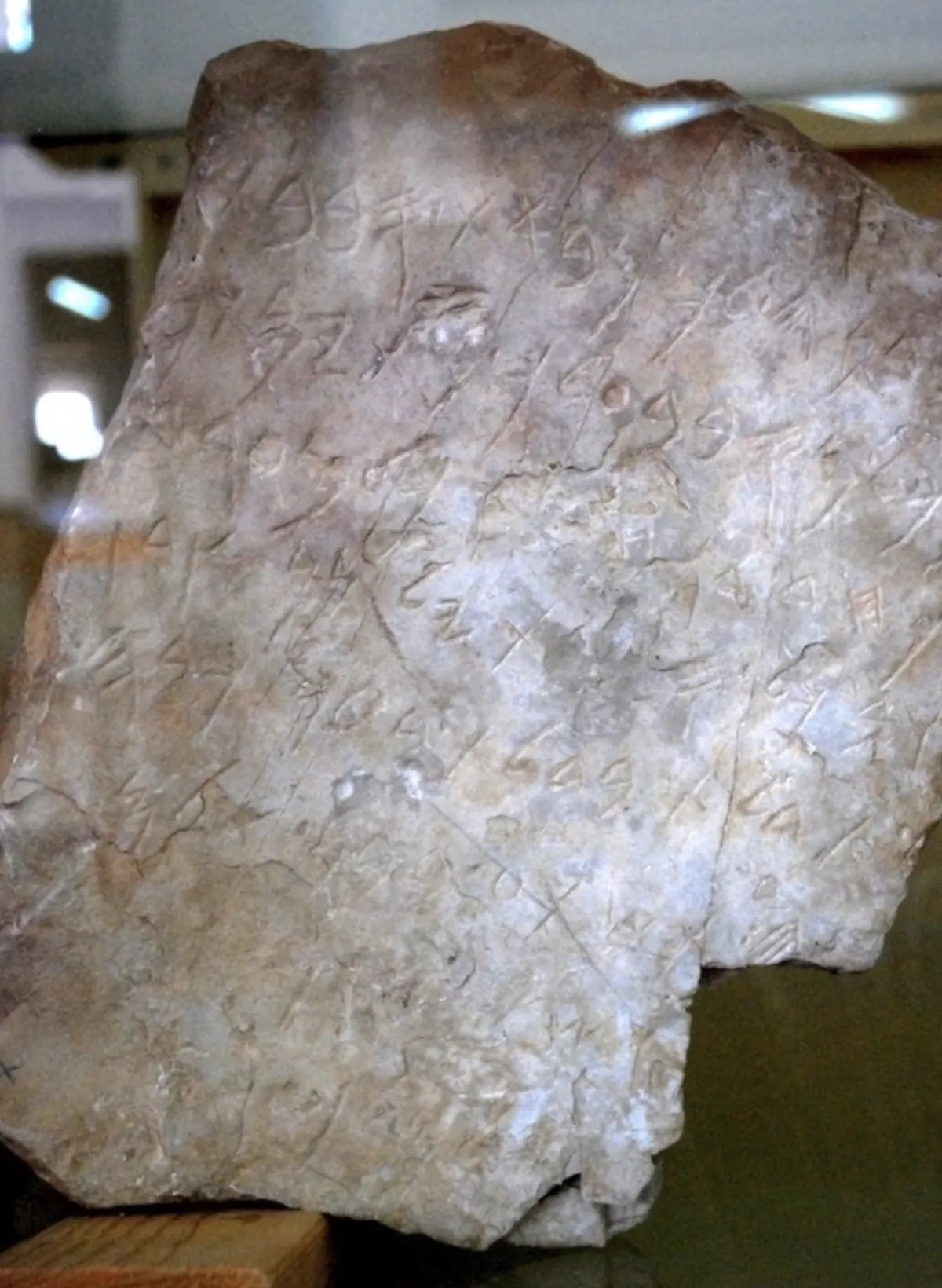 Small broken limestone block with eight lines of ancient alphabetic writing