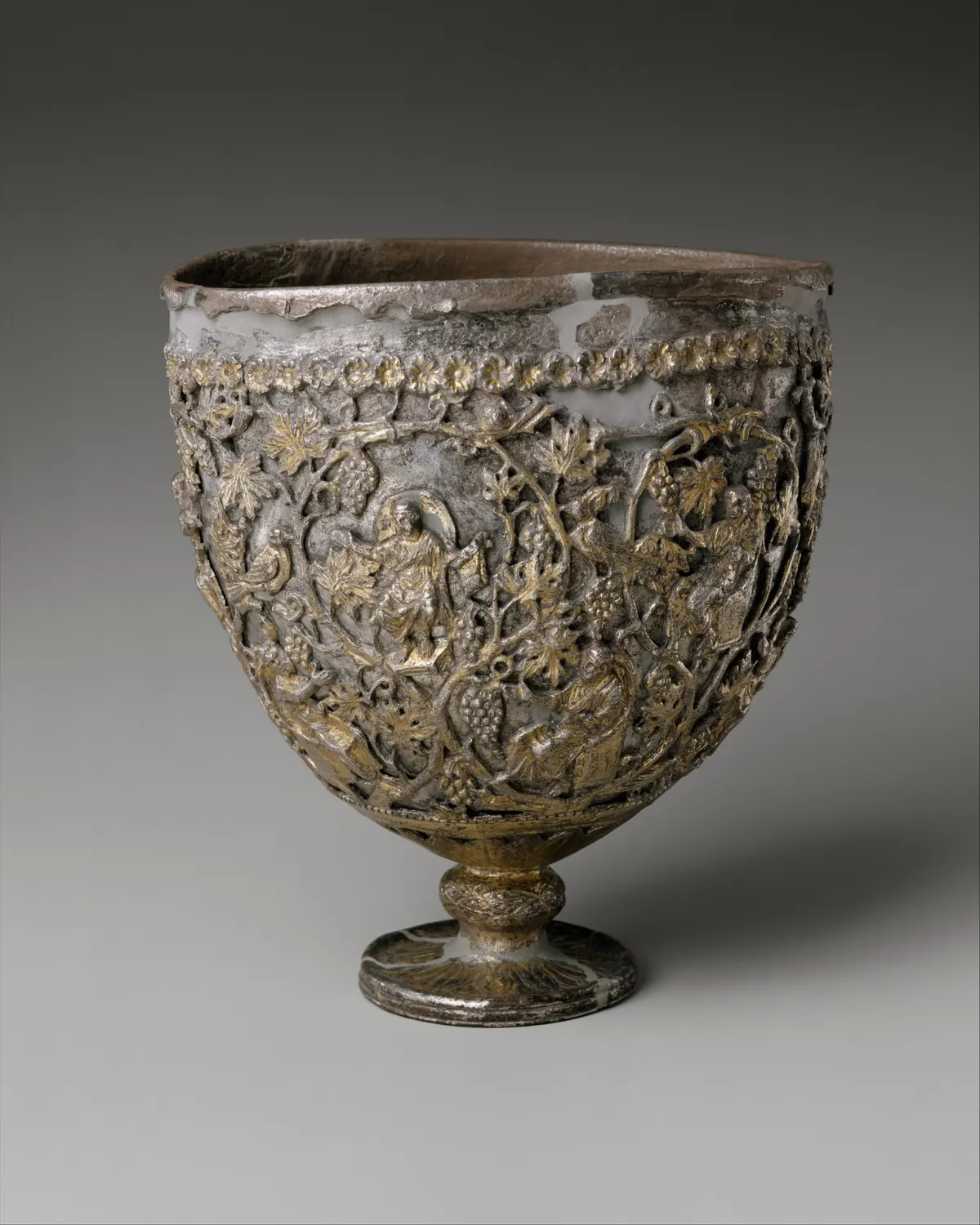 Silver cup enclosed in gilded openwork with figures among vines