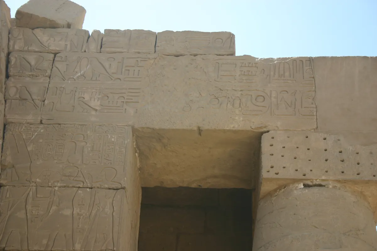 Carved temple wall with rows of bound captive figures and hieroglyphs