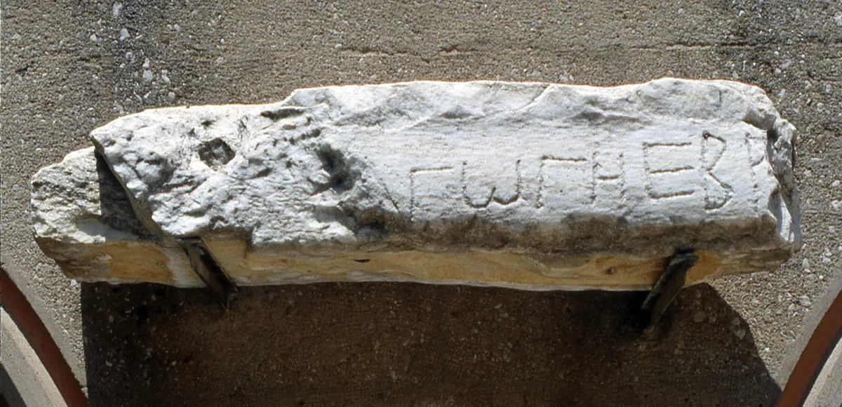 Broken marble block with rough Greek letters