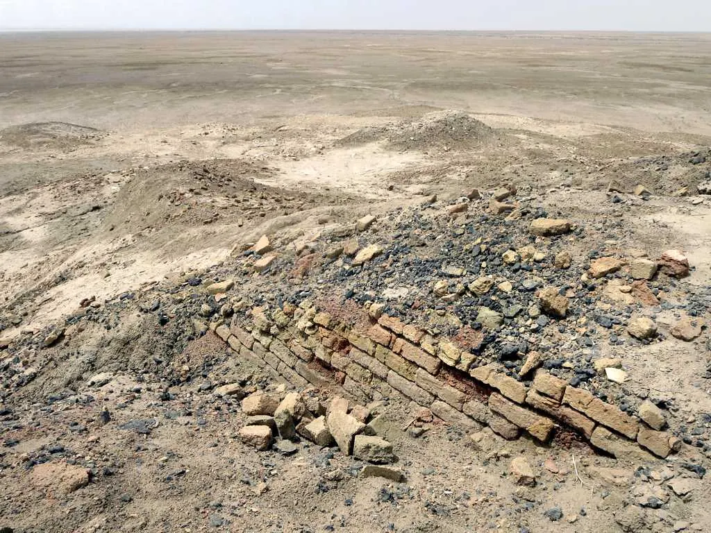 Low desert mound with eroded brickwork