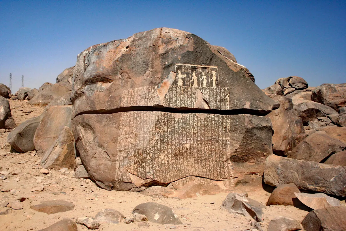 Granite boulder covered with columns of hieroglyphs beside the Nile