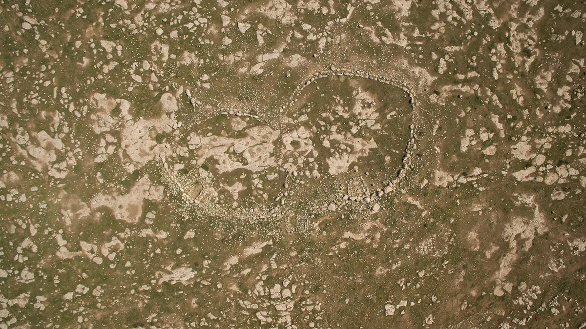 Aerial view of a low stone wall enclosure shaped like a foot