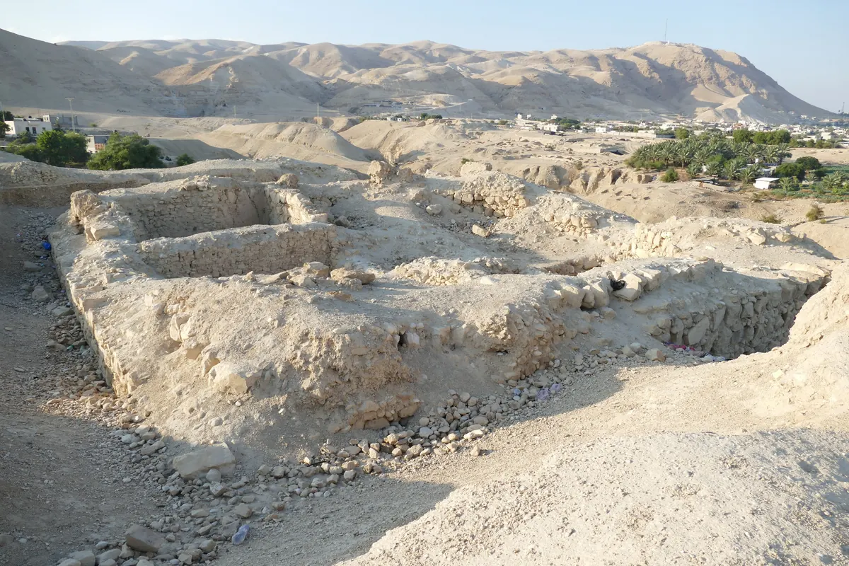Excavated plastered pools and mud-brick walls in an oasis landscape