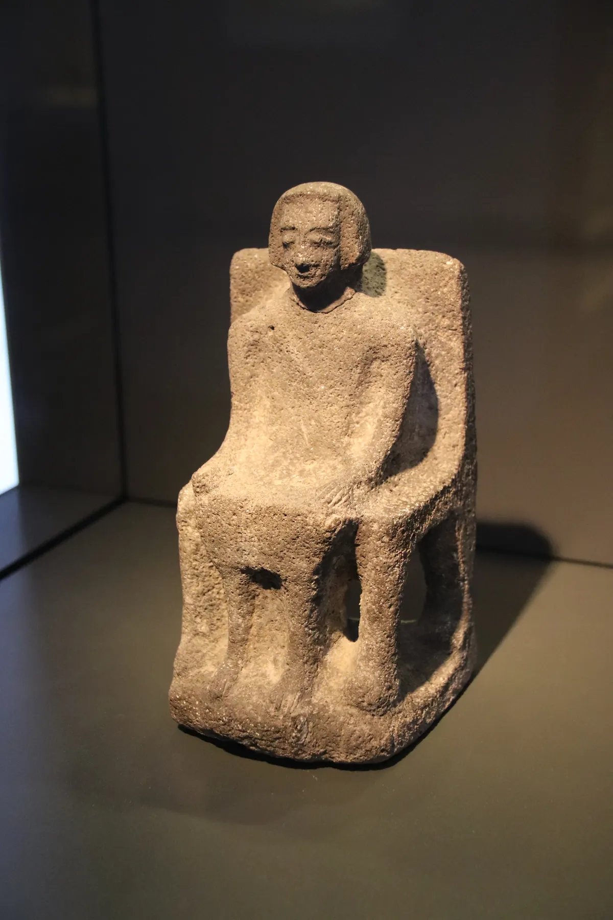 Headless seated basalt statue