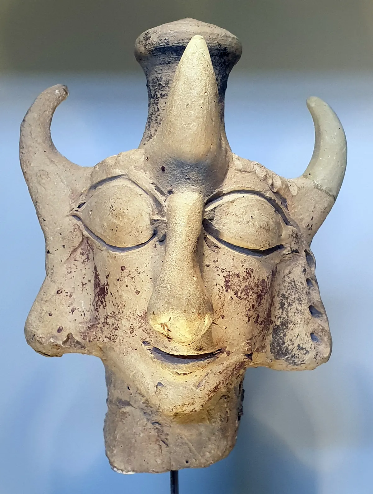 Painted clay head of a goddess with three horns