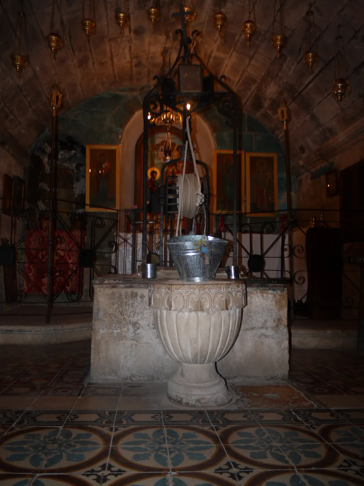 Stone well-head with a bucket inside a church crypt