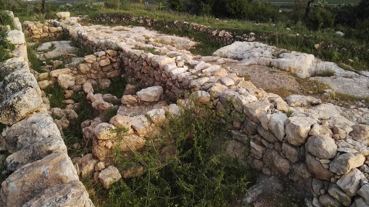 Large stone wall foundations on a hilltop overlooking a valley