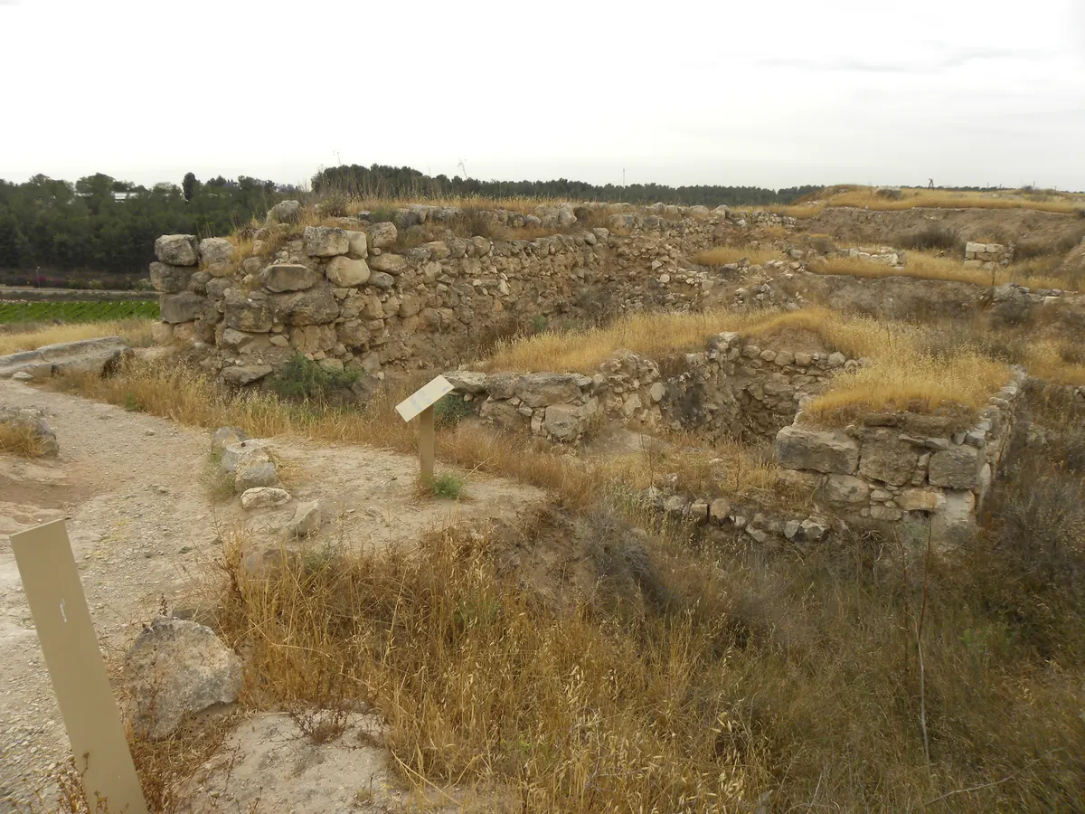 Excavated stone chamber with benches and a carved stone seat