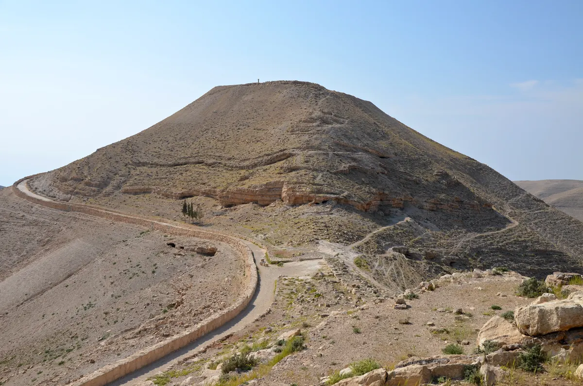 Hilltop ruins with re-erected columns overlooking a desert valley