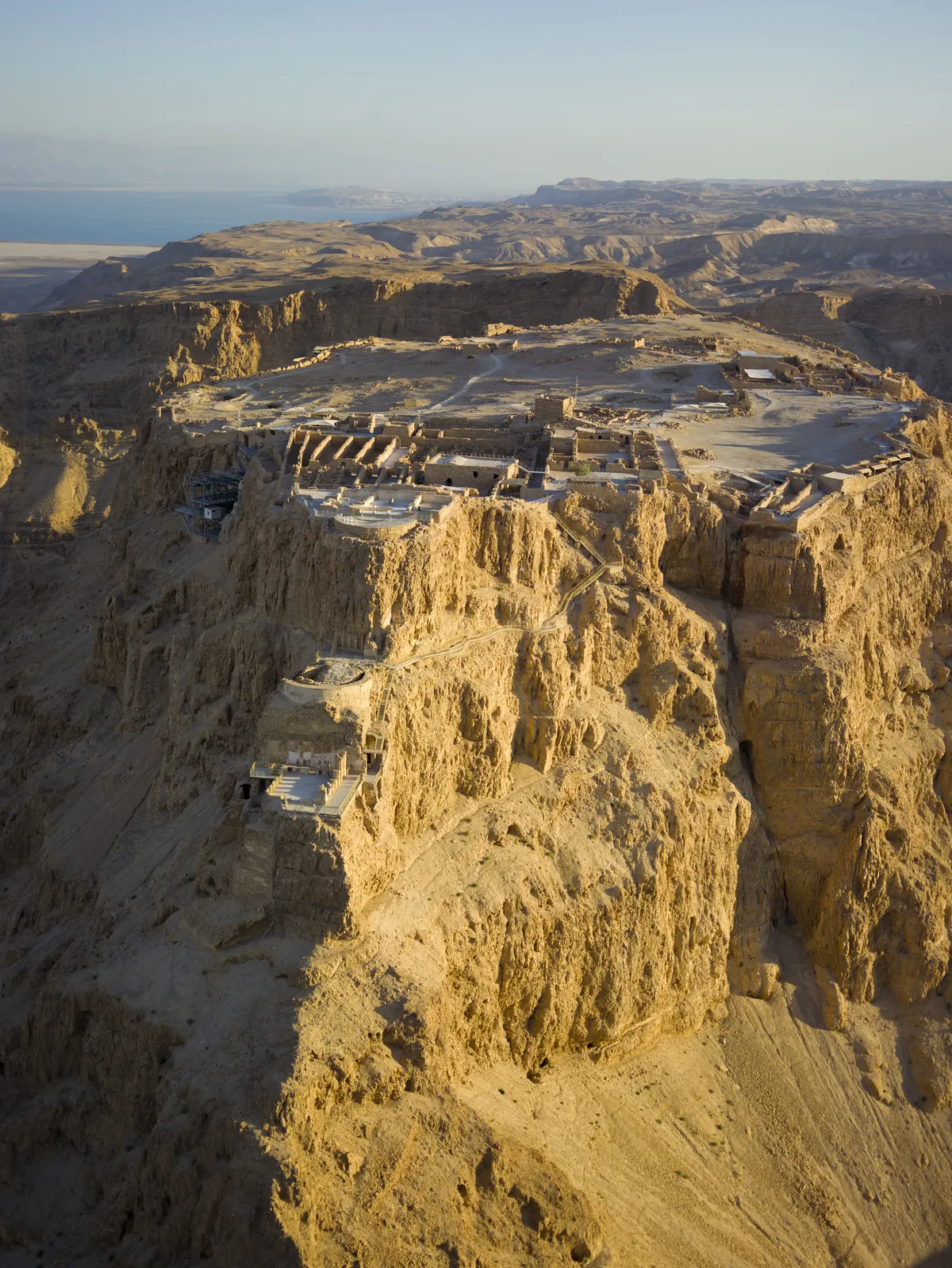 Aerial view of a flat-topped desert mountain with ruins on its summit