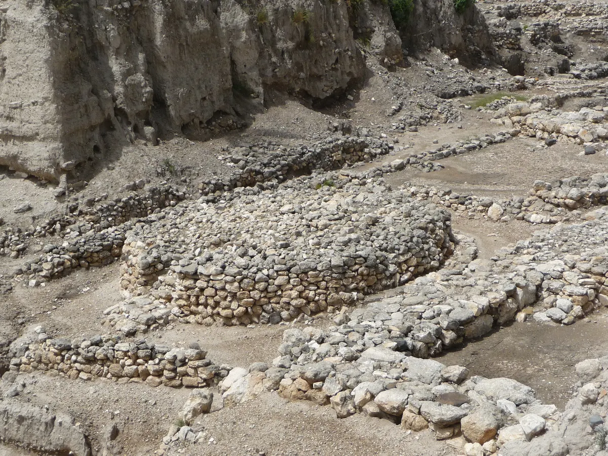 Rows of standing stone pillars and troughs in an excavated area