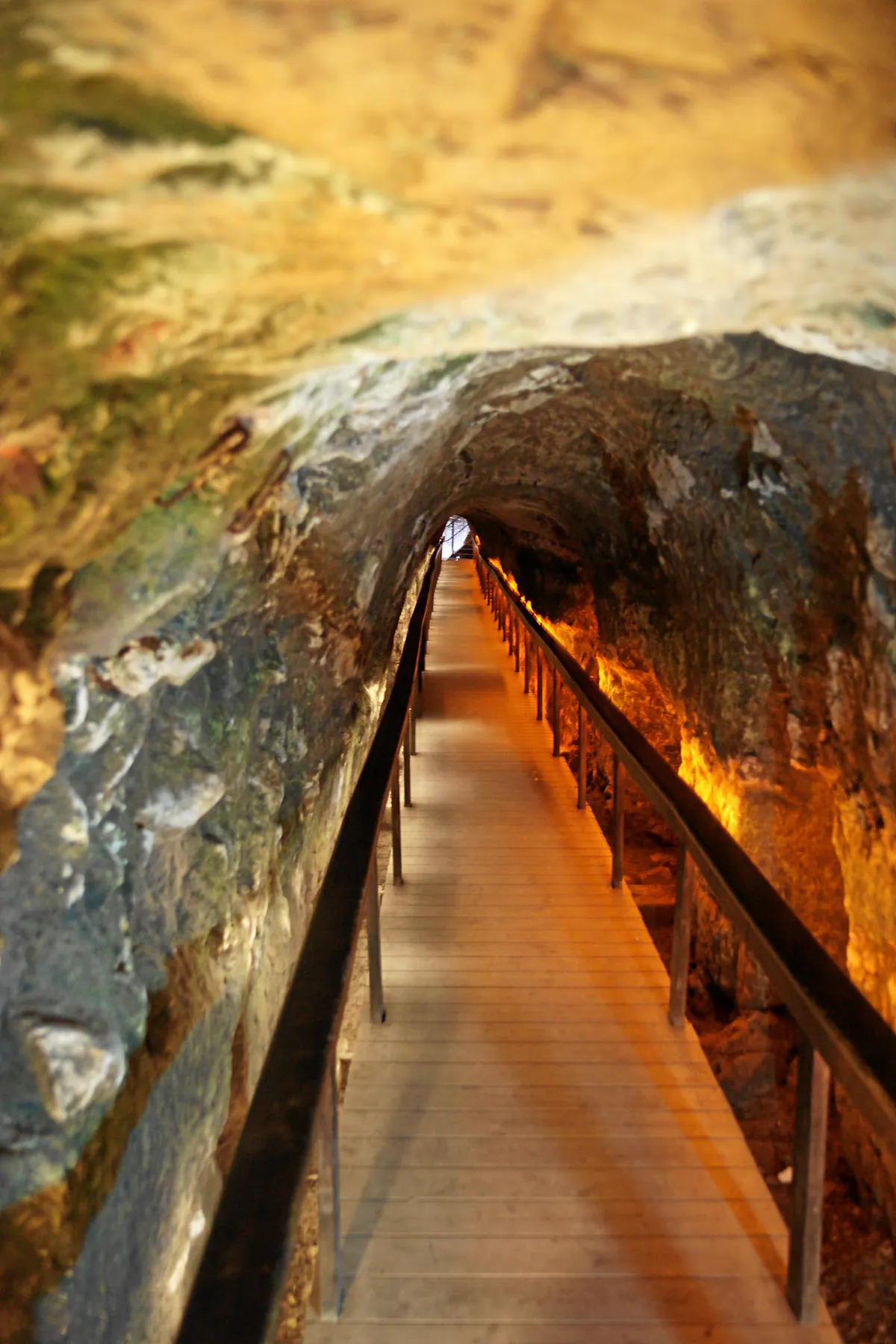 Long rock-cut tunnel with a modern walkway and lights