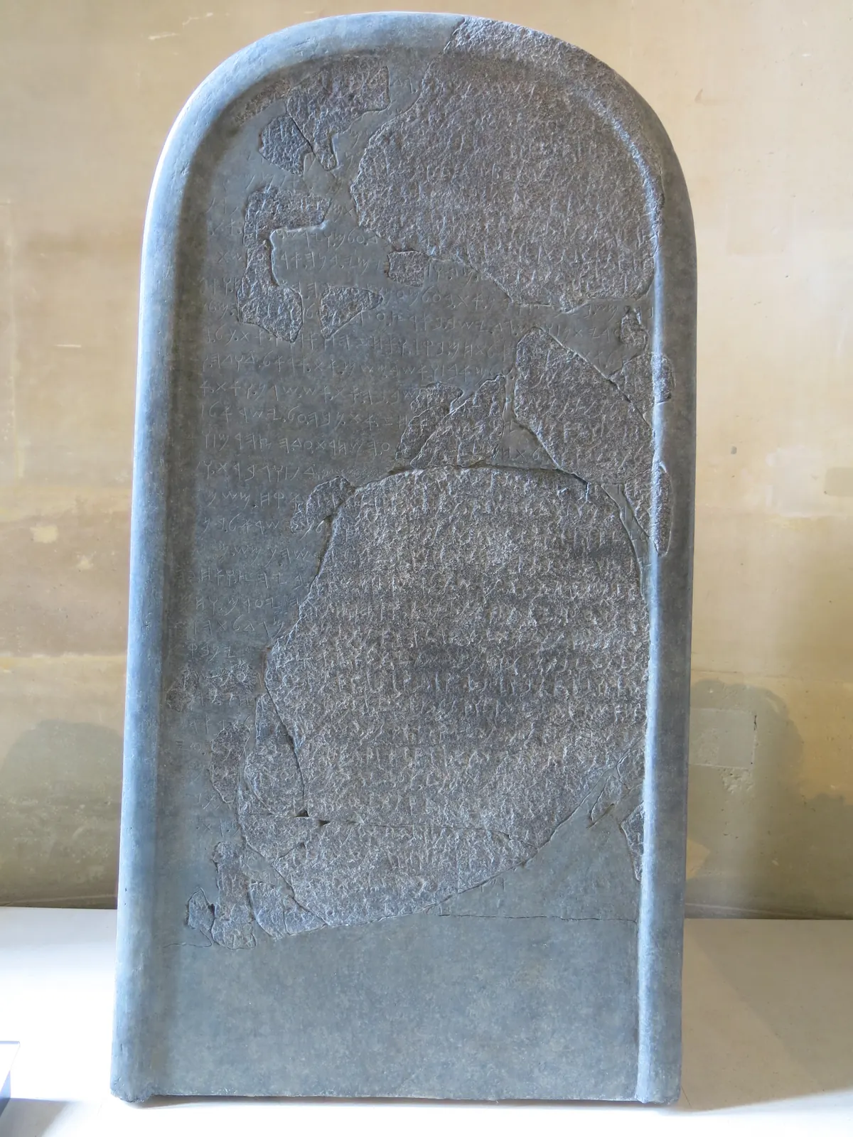 Tall black basalt stele covered in Moabite alphabetic writing