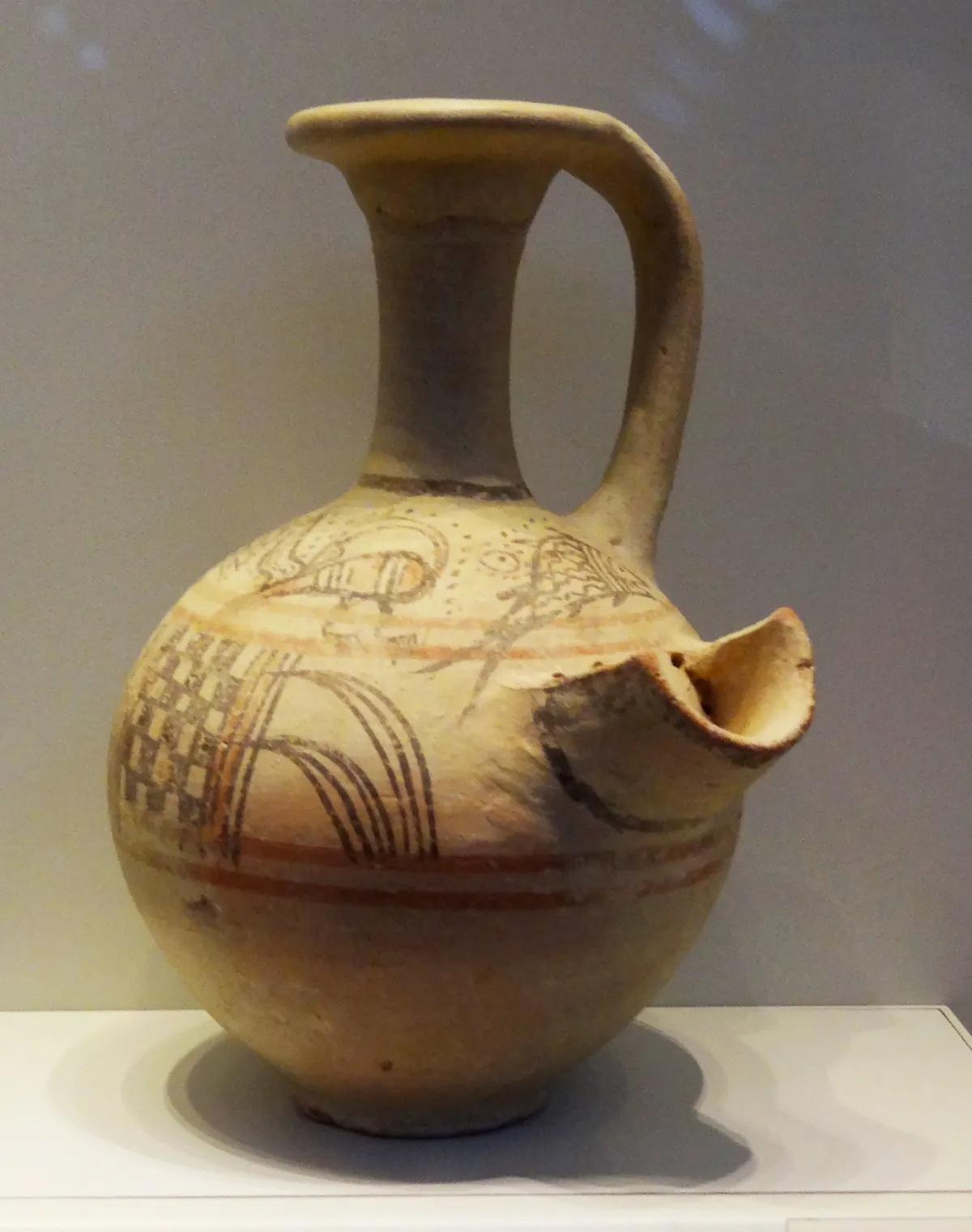 Painted clay jug with red and black bird and spiral designs