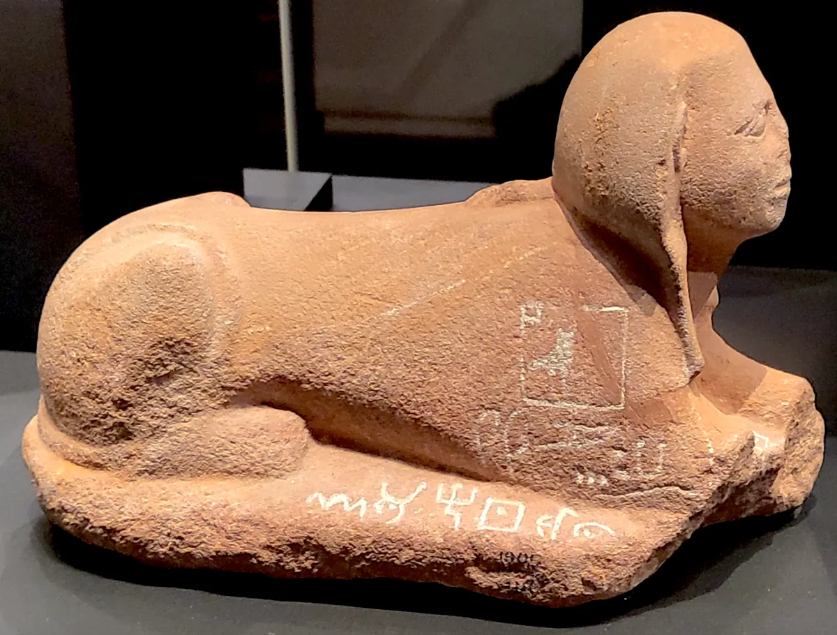 Small sandstone sphinx with alphabetic signs along its side