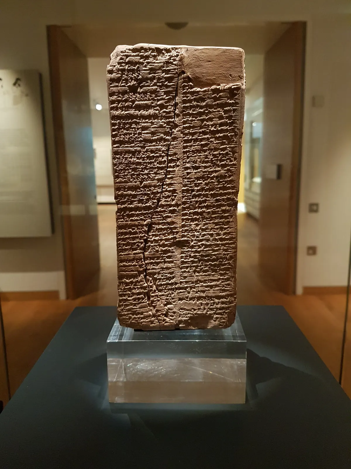 Tall four-sided clay prism covered in cuneiform