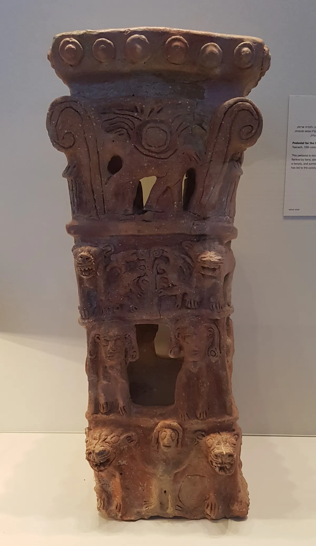Tall terracotta stand with four tiers of molded animal and human figures