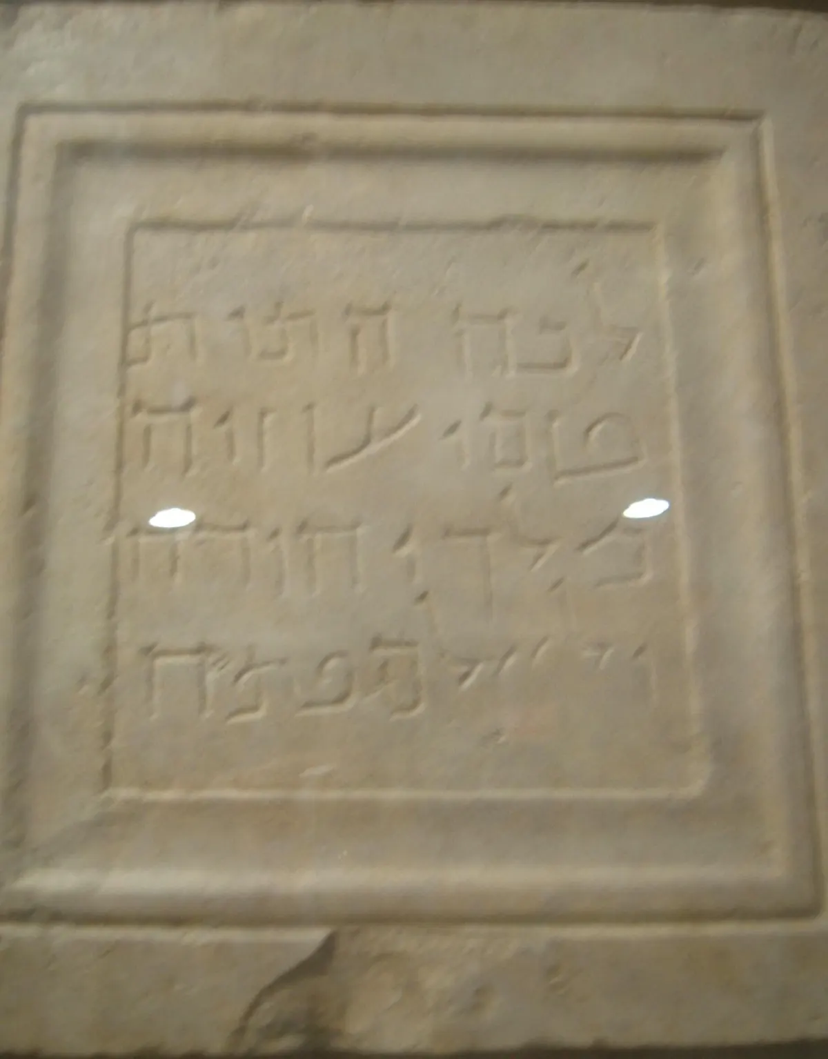 Square limestone plaque with four lines of square Hebrew-Aramaic letters