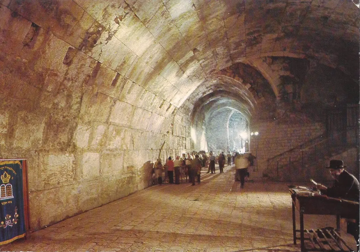 Curved stone steps of a small theater beneath a large stone arch